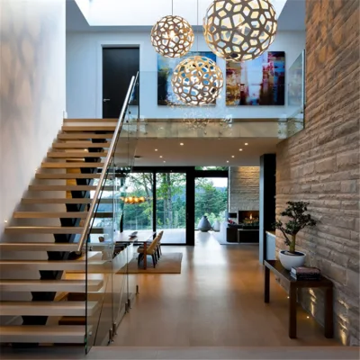 Современная прямая стально-деревянная лестница со стеклянной балюстрадой и ступенями из массива дерева.